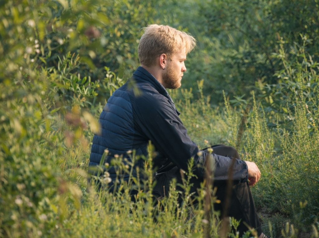 Man sitting quietly in tall green grass